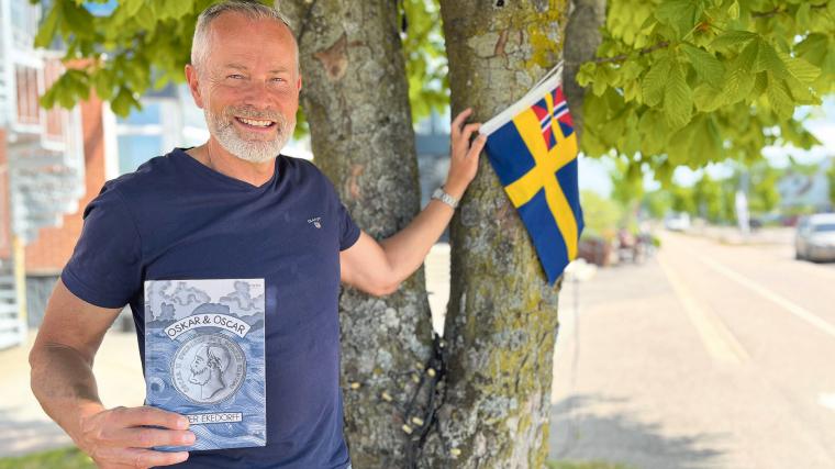 Författaren Per Ekedorff med sin debutroman ”Oskar & Oscar” i ena handen och unionsflaggan i den andra. När kung Oscar II, som har en stor roll i boken, regerade användes flaggan då Sverige och Norge var en union från 1814 – 1905. Flaggan kallades för övrigt ”sillsallaten”.