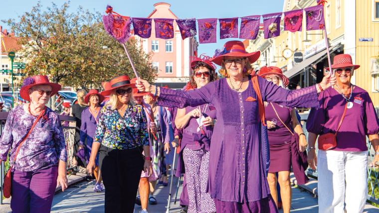 Genom staden tågade damerna. För att vara med i sällskapet Rhapsody in red and purple behöver man fyllt 50 år.